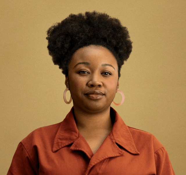 A woman with a poised expression against a plain background